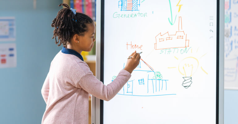 Young Black student at a smart whiteboard drawing on a science diagram.